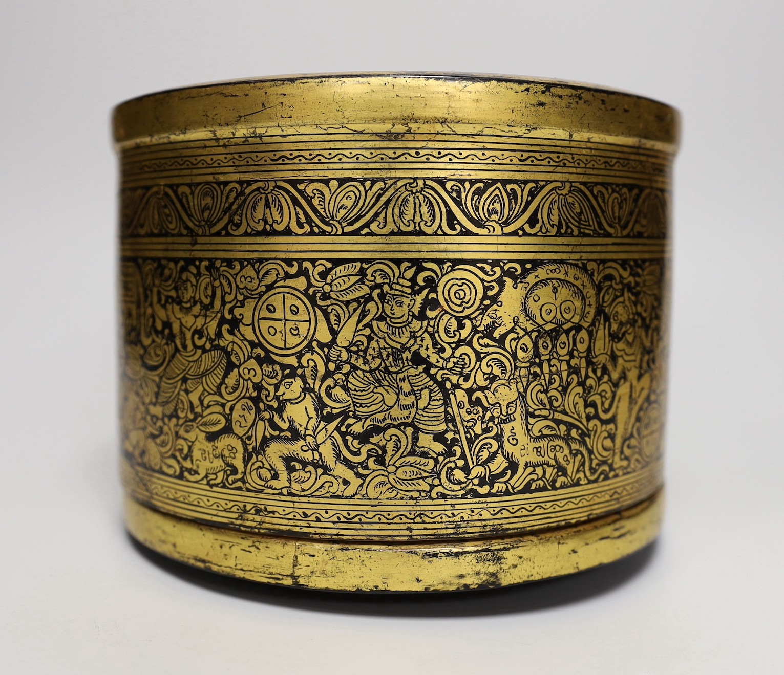 A Burmese gilt decorated papier mache cylindrical box and cover, 14cms high